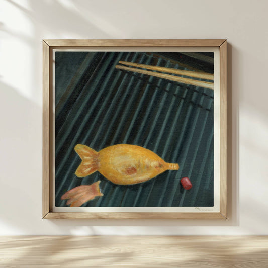 Goldener Fisch auf Sushi-Matte mit Stäbchen, surreal inszeniert.. Rahmen natur 30x30