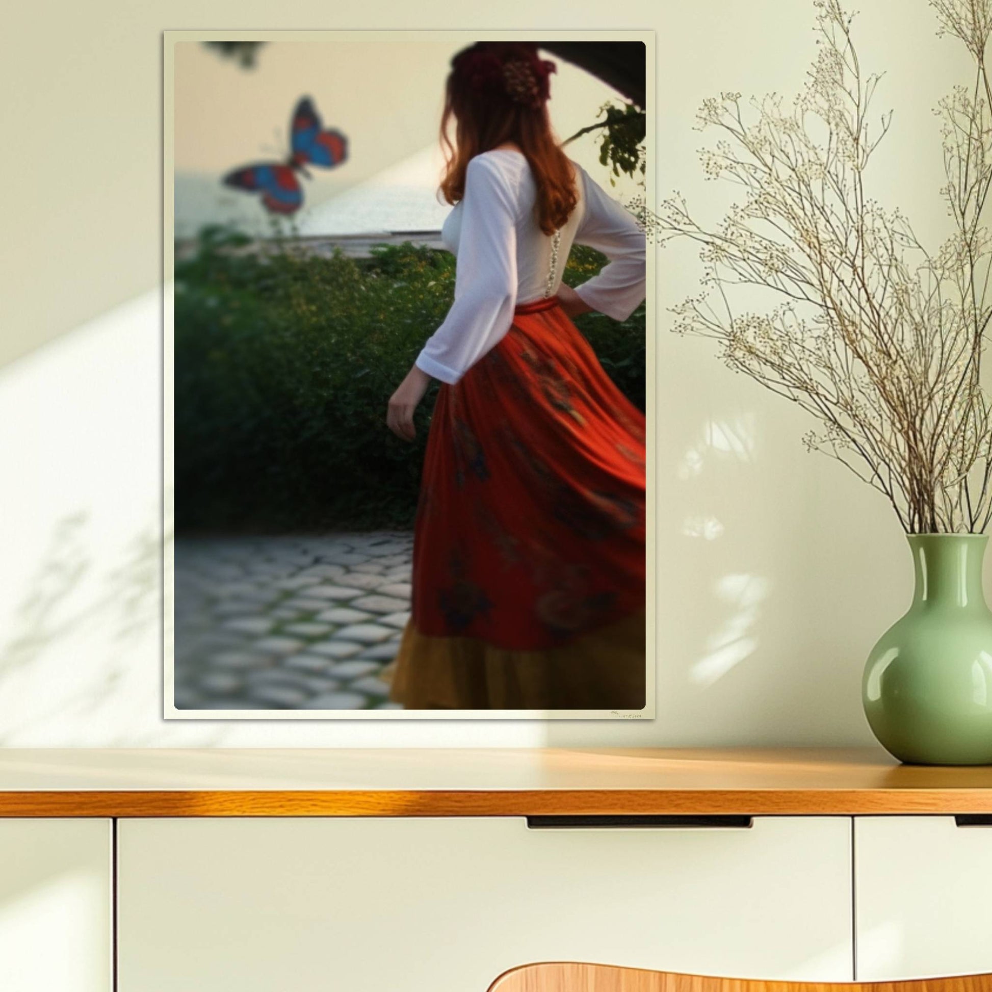 Eine Frau in folkloristischer Kleidung tanzt auf Kopfsteinpflaster durch einen Steinbogen, im Hintergrund ein großer Schmetterling am Meer.. Ohne Rahmen 50x70