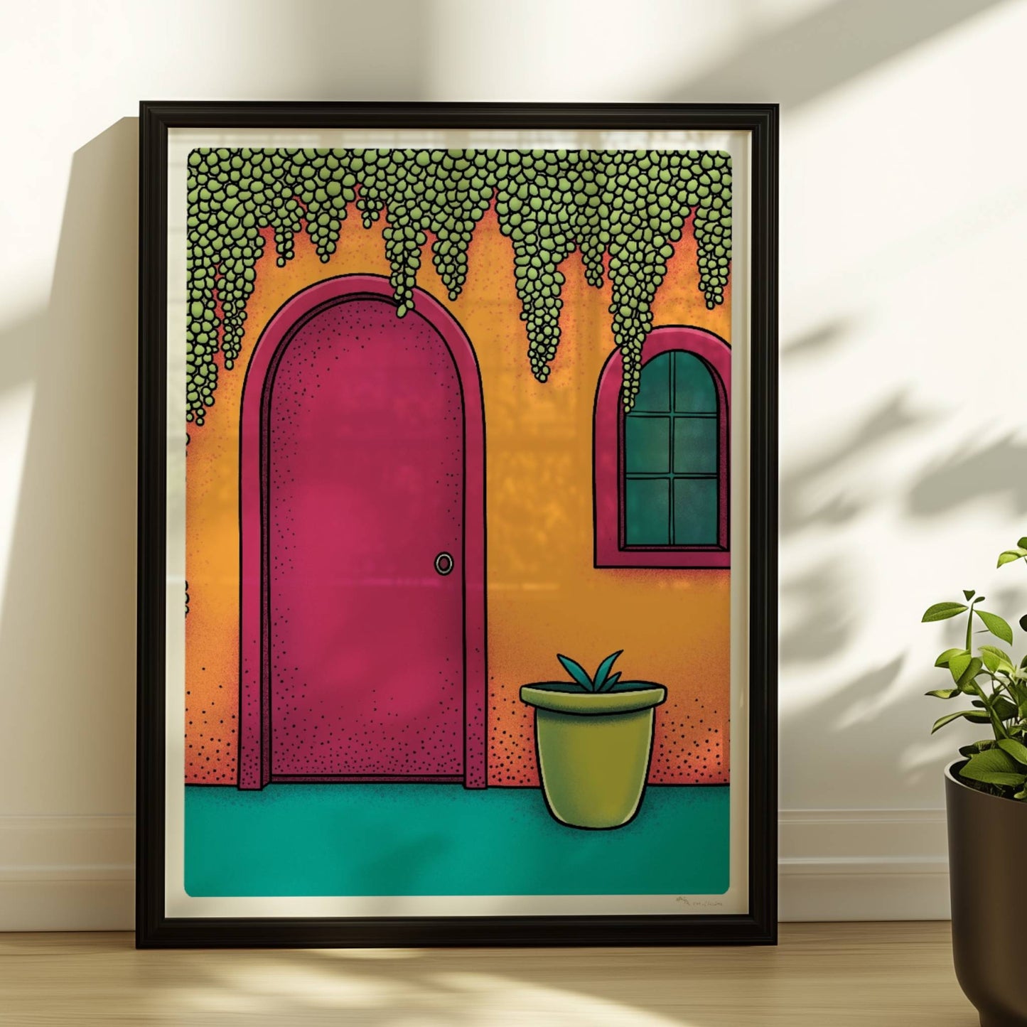 Orangefarbene Hausfassade mit bogenförmiger rosa Tür, hängenden Traubenpflanzen und Fenster – mediterranes Urlaubsarchitektur-Motiv. Rahmen schwarz 30x40