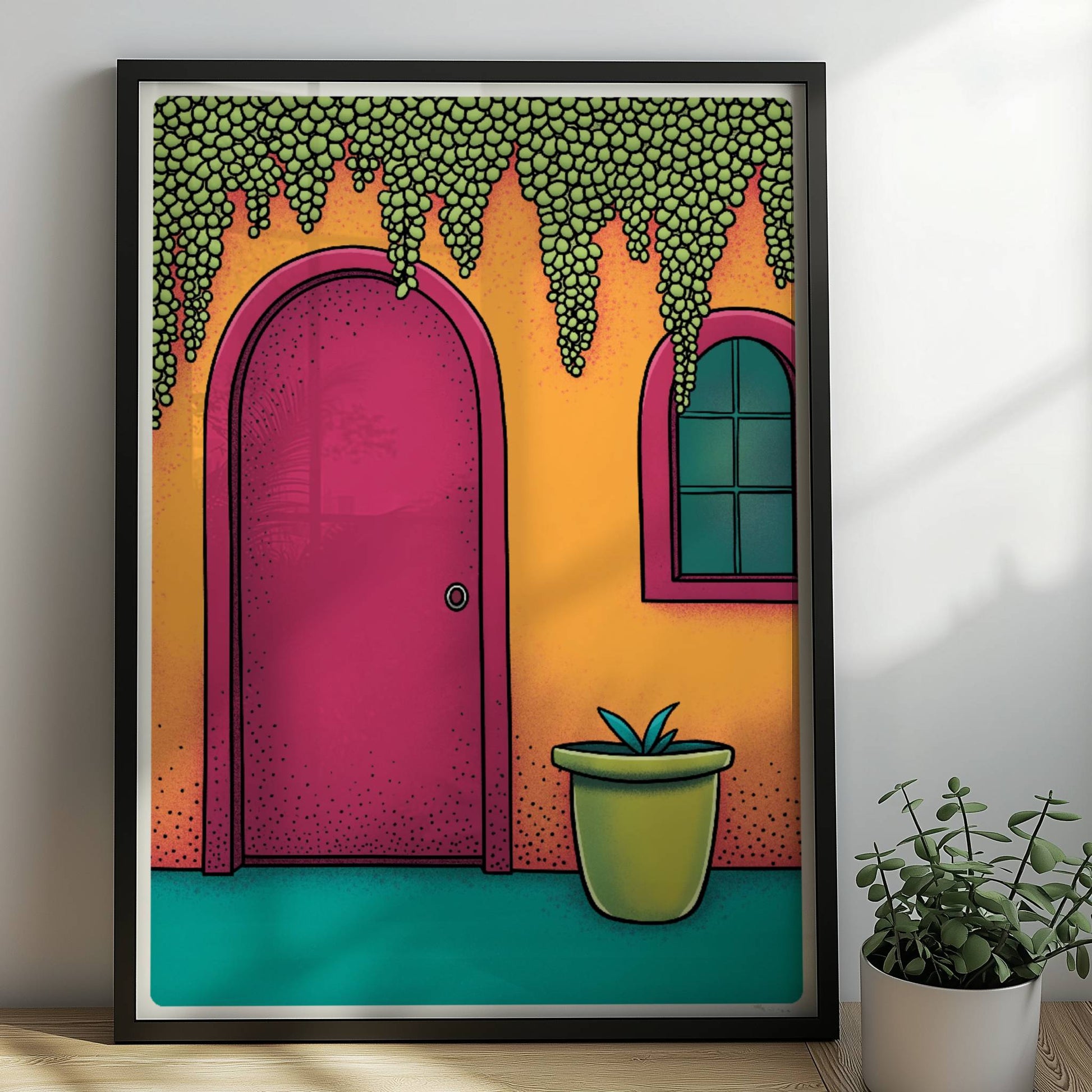 Orangefarbene Hausfassade mit bogenförmiger rosa Tür, hängenden Traubenpflanzen und Fenster – mediterranes Urlaubsarchitektur-Motiv. Rahmen schwarz 50x70