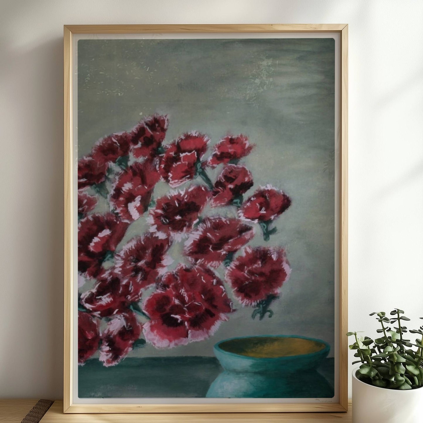 Fliegende rote Nelken in grüner Vase vor grauem Hintergrund.. Rahmen natur 50x70