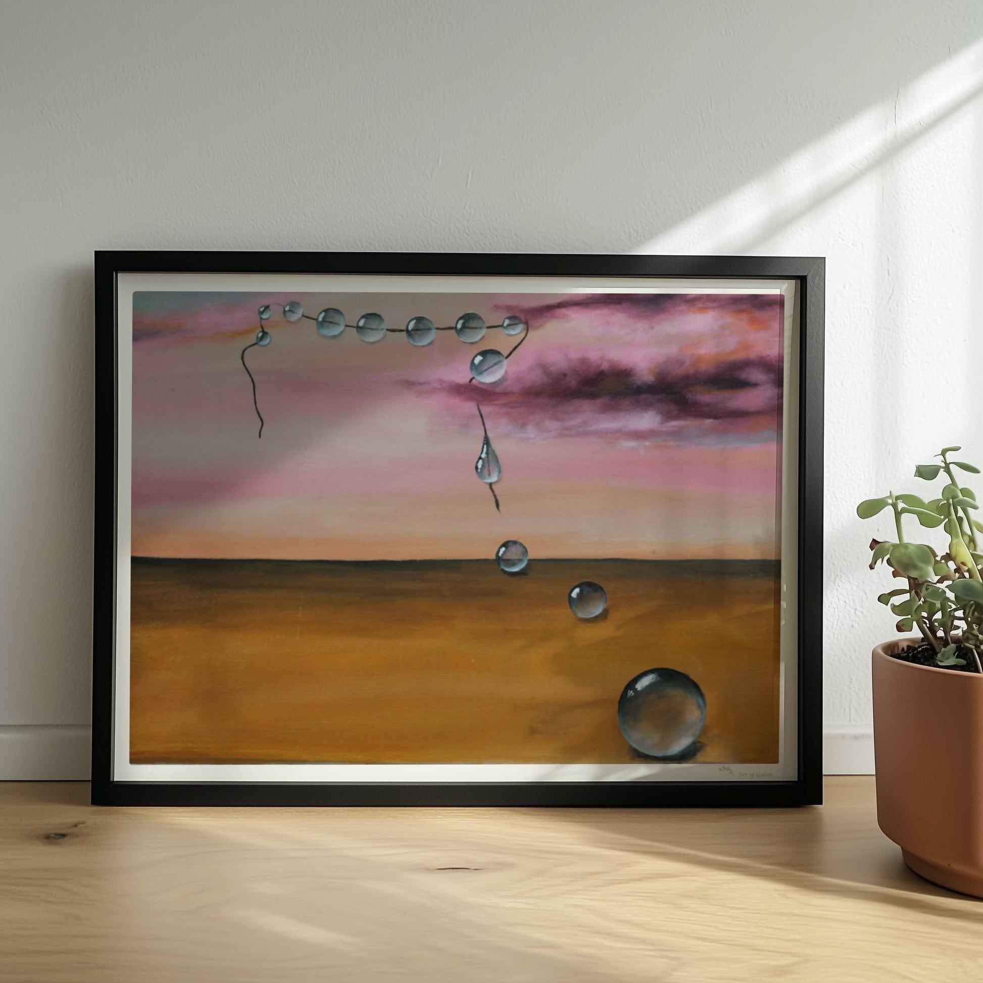 13 schwebende Glastropfen vor rosarotem Himmel über Wüste.. Rahmen schwarz 40x30