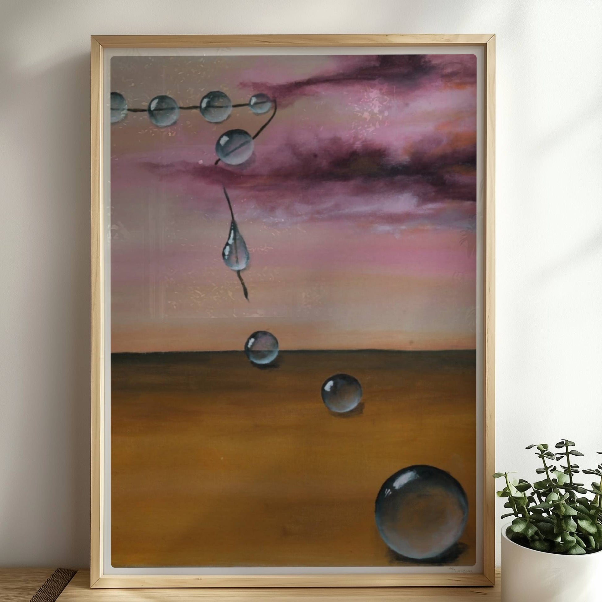 13 schwebende Glastropfen vor rosarotem Himmel über Wüste.. Rahmen natur 50x70