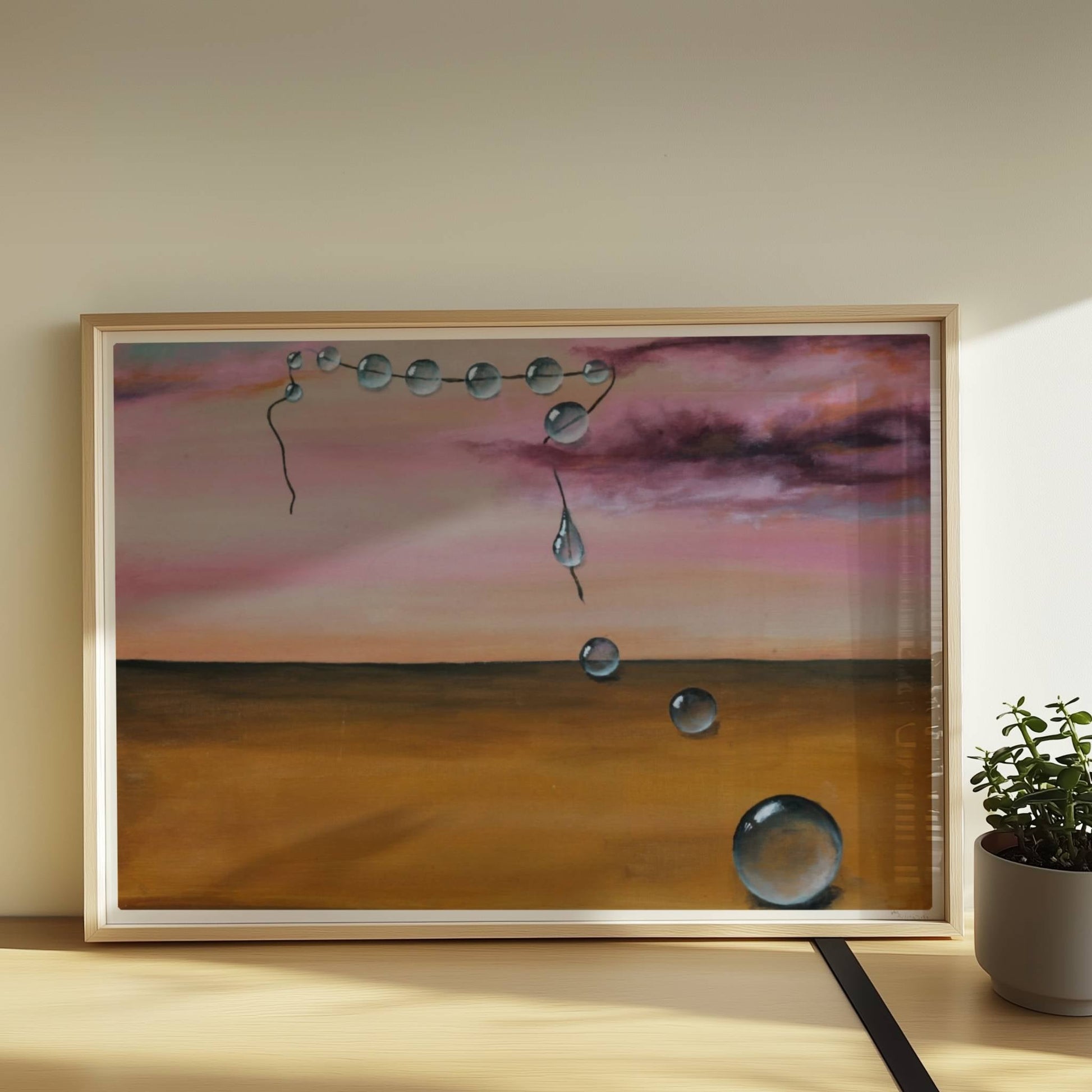 13 schwebende Glastropfen vor rosarotem Himmel über Wüste.. Rahmen natur 70x50