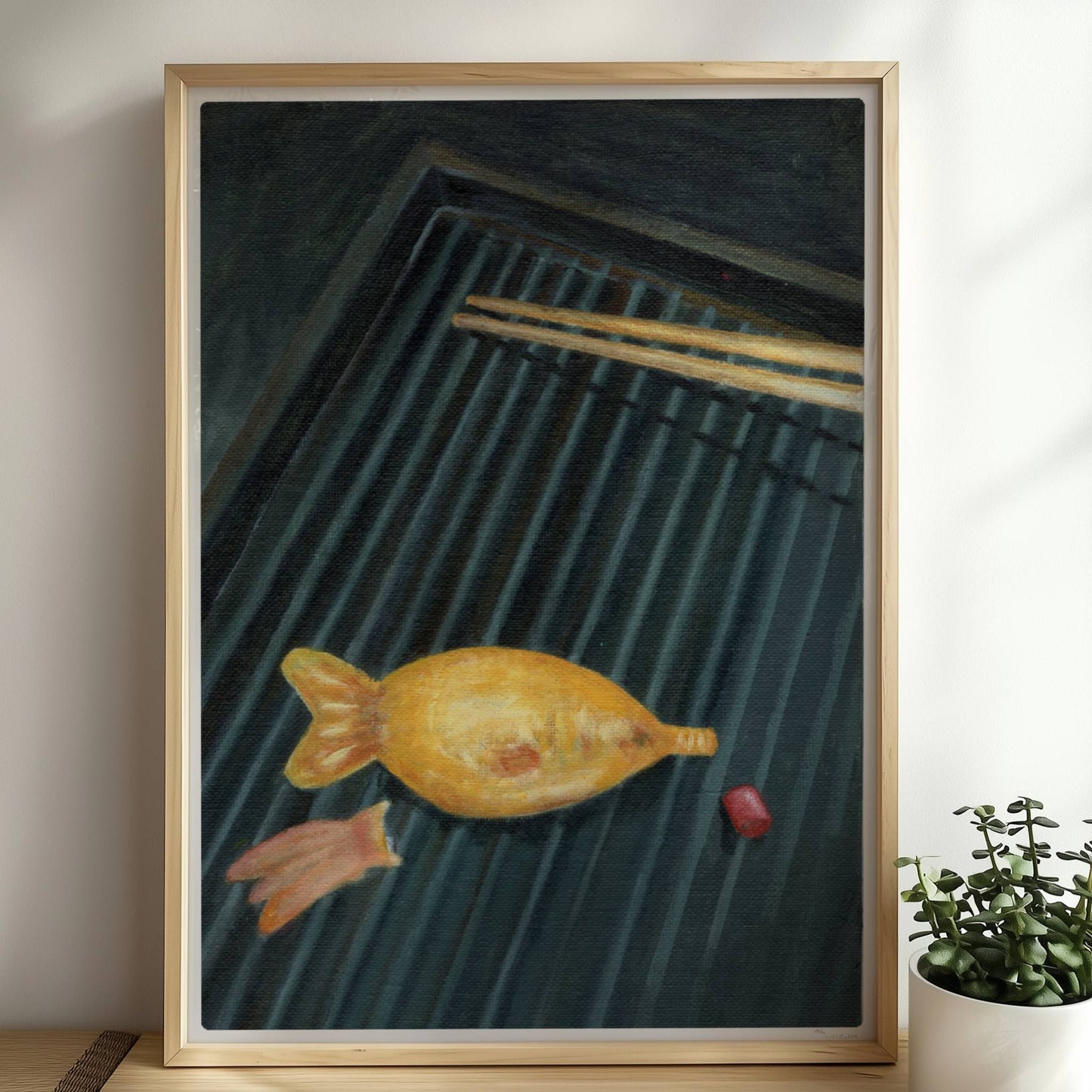 Goldener Fisch auf Sushi-Matte mit Stäbchen, surreal inszeniert.. Rahmen natur 50x70