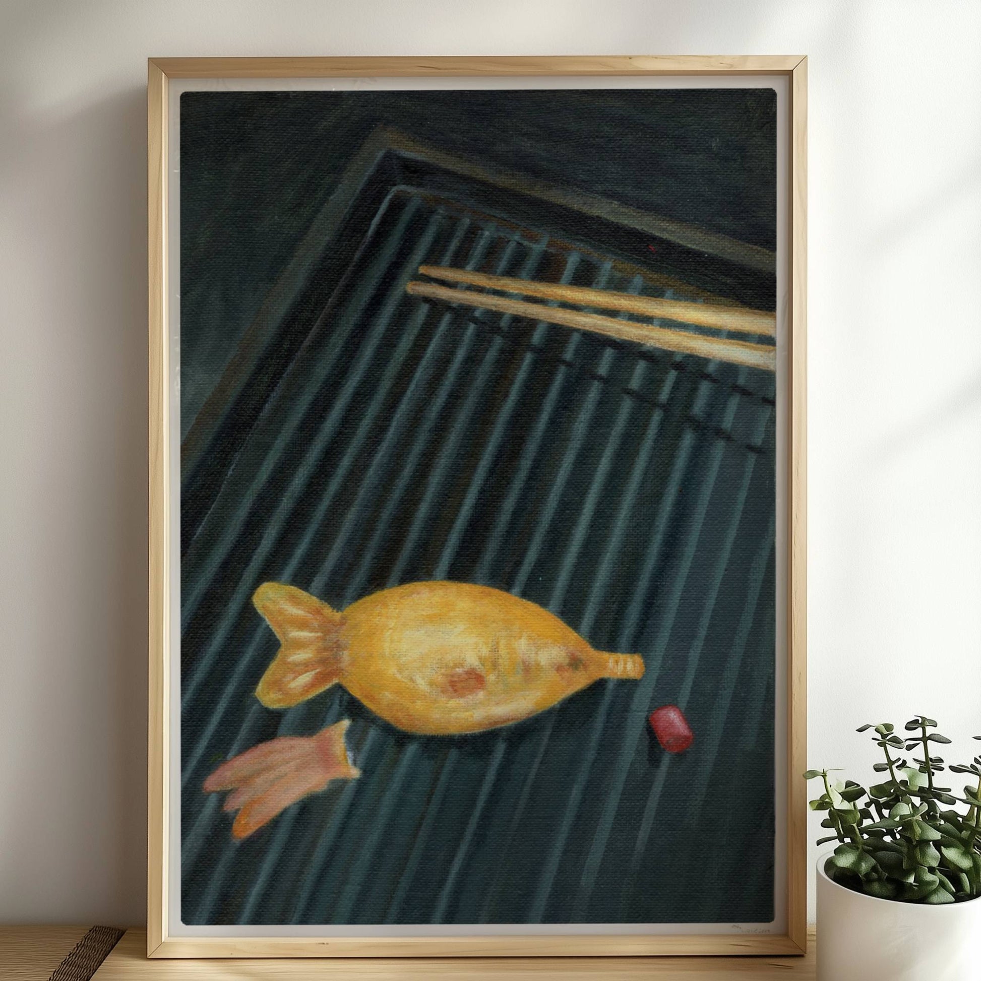 Goldener Fisch auf Sushi-Matte mit Stäbchen, surreal inszeniert.. Rahmen natur 50x70
