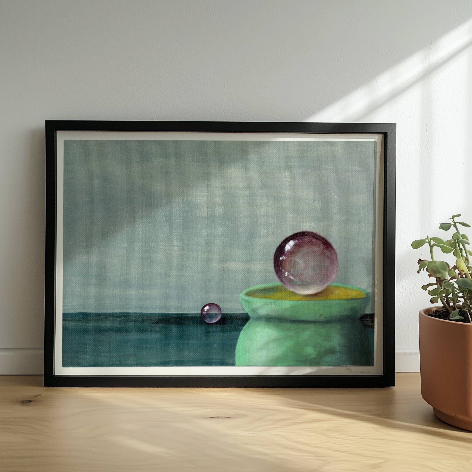 Schwebende Glaskugel über grüner Schale, minimalistische Szene.. Rahmen schwarz 40x30