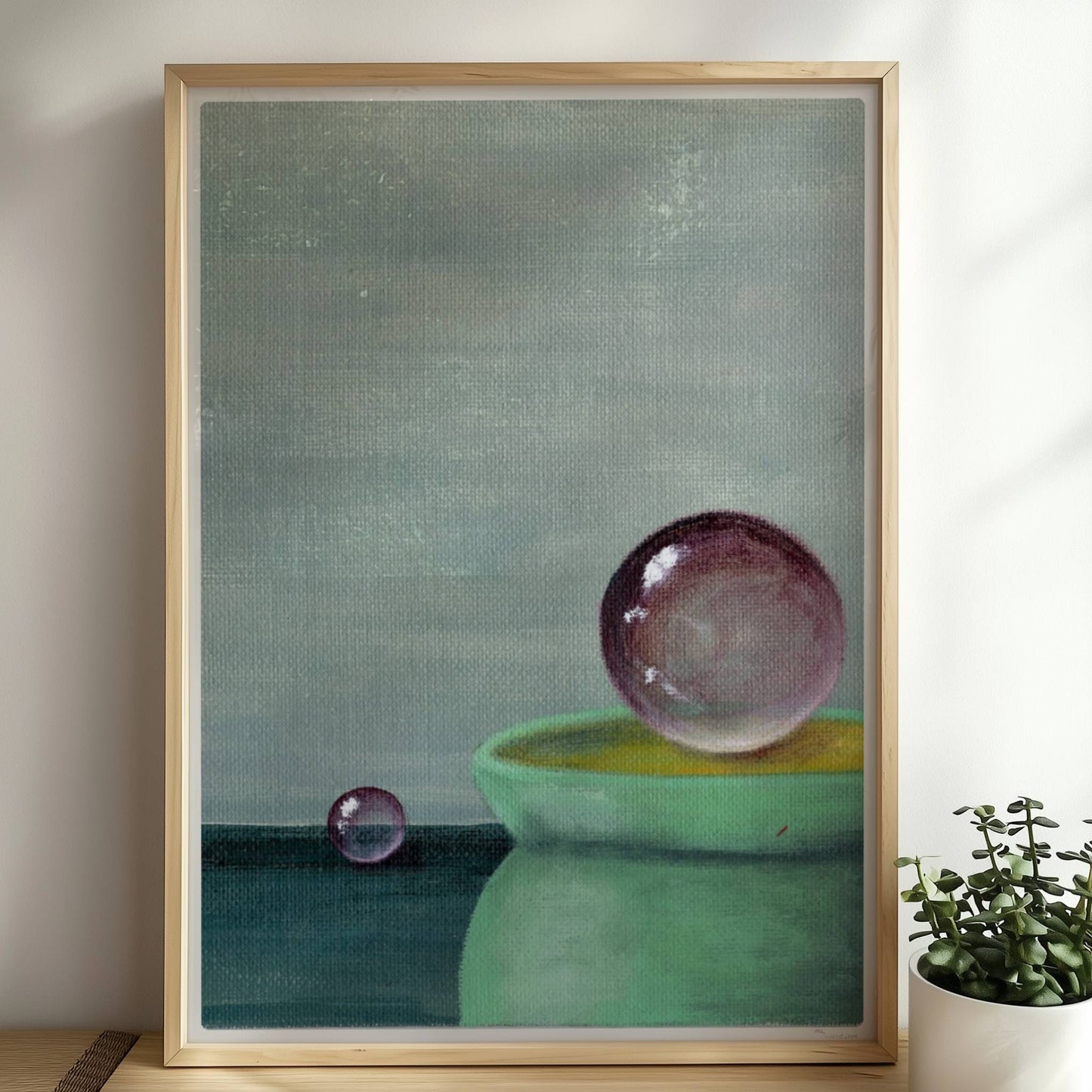Schwebende Glaskugel über grüner Schale, minimalistische Szene.. Rahmen natur 50x70