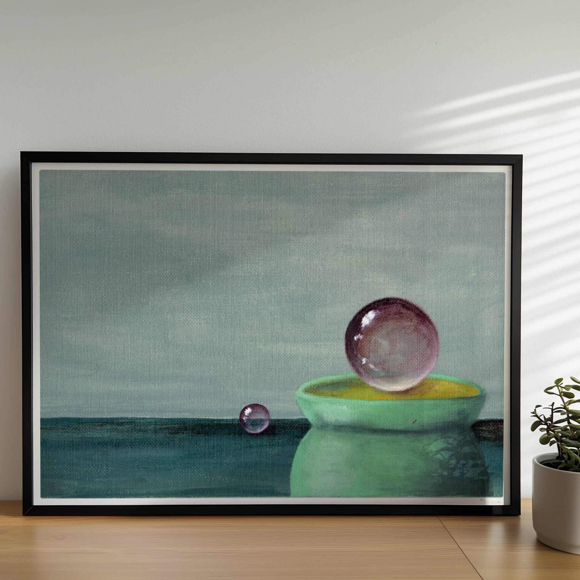 Schwebende Glaskugel über grüner Schale, minimalistische Szene.. Rahmen schwarz 70x50