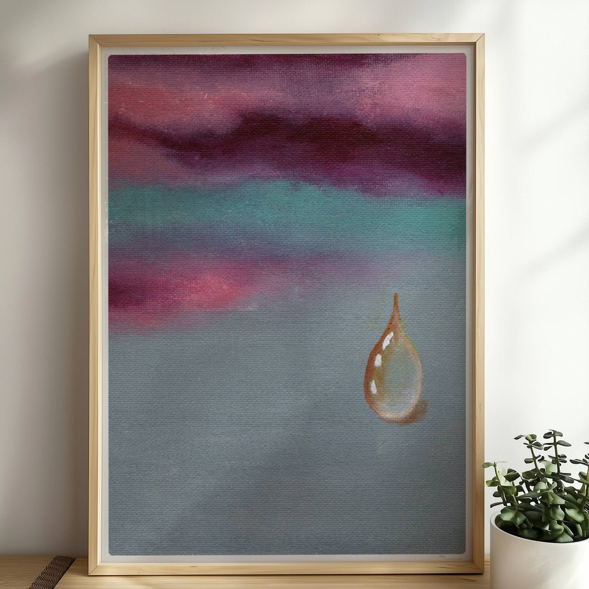 Goldener Tropfen vor dramatischem Himmel in Violett und Türkis.. Rahmen natur 50x70