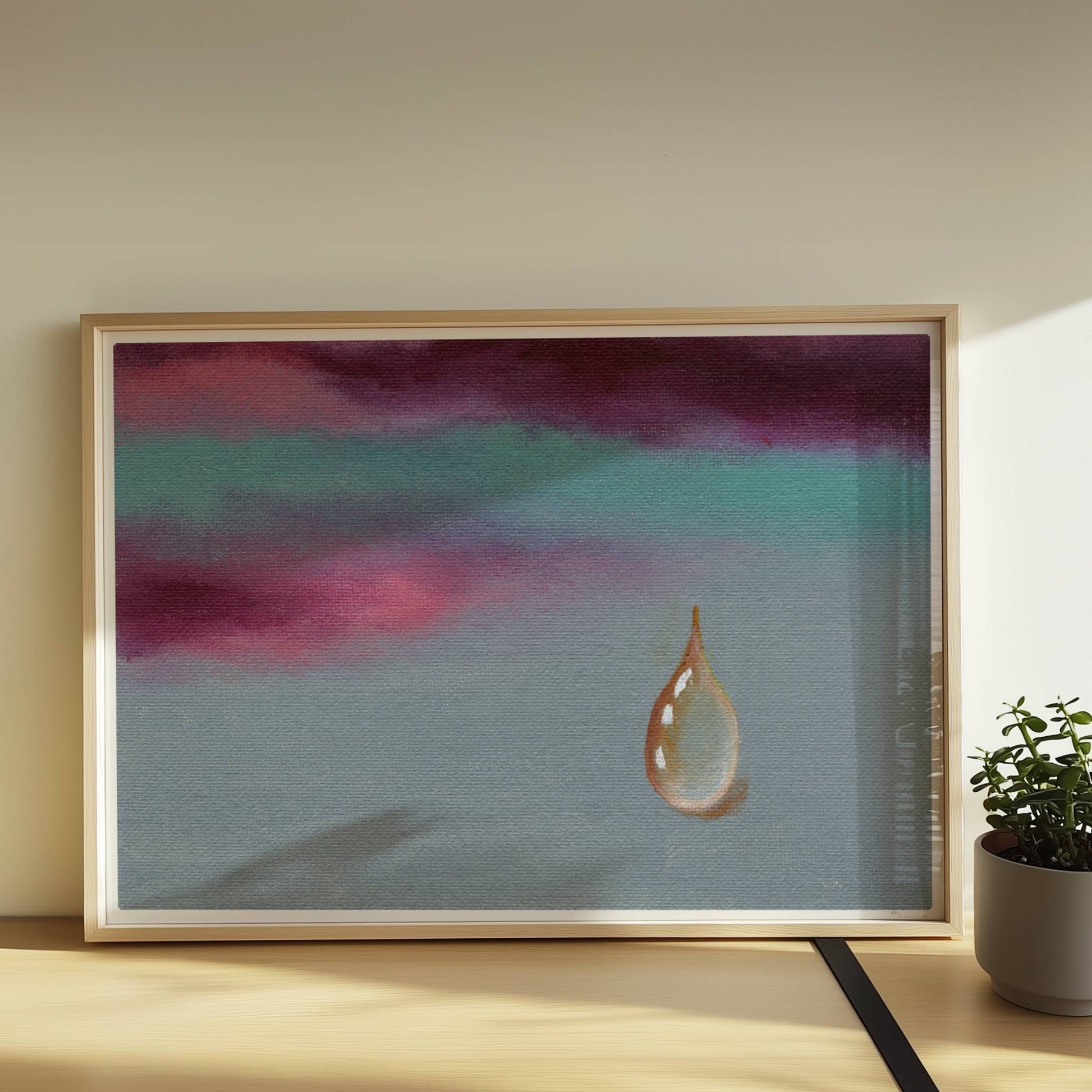 Goldener Tropfen vor dramatischem Himmel in Violett und Türkis.. Rahmen natur 70x50