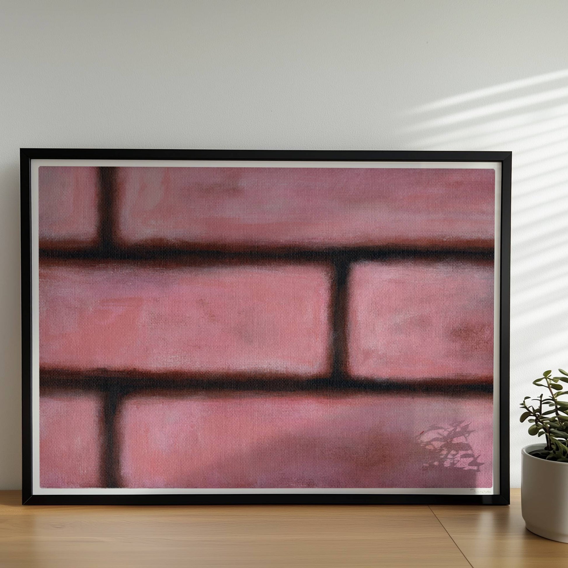 Rosafarbene Ziegelwand mit weichen Kanten und künstlerischem Flair.. Rahmen schwarz 70x50