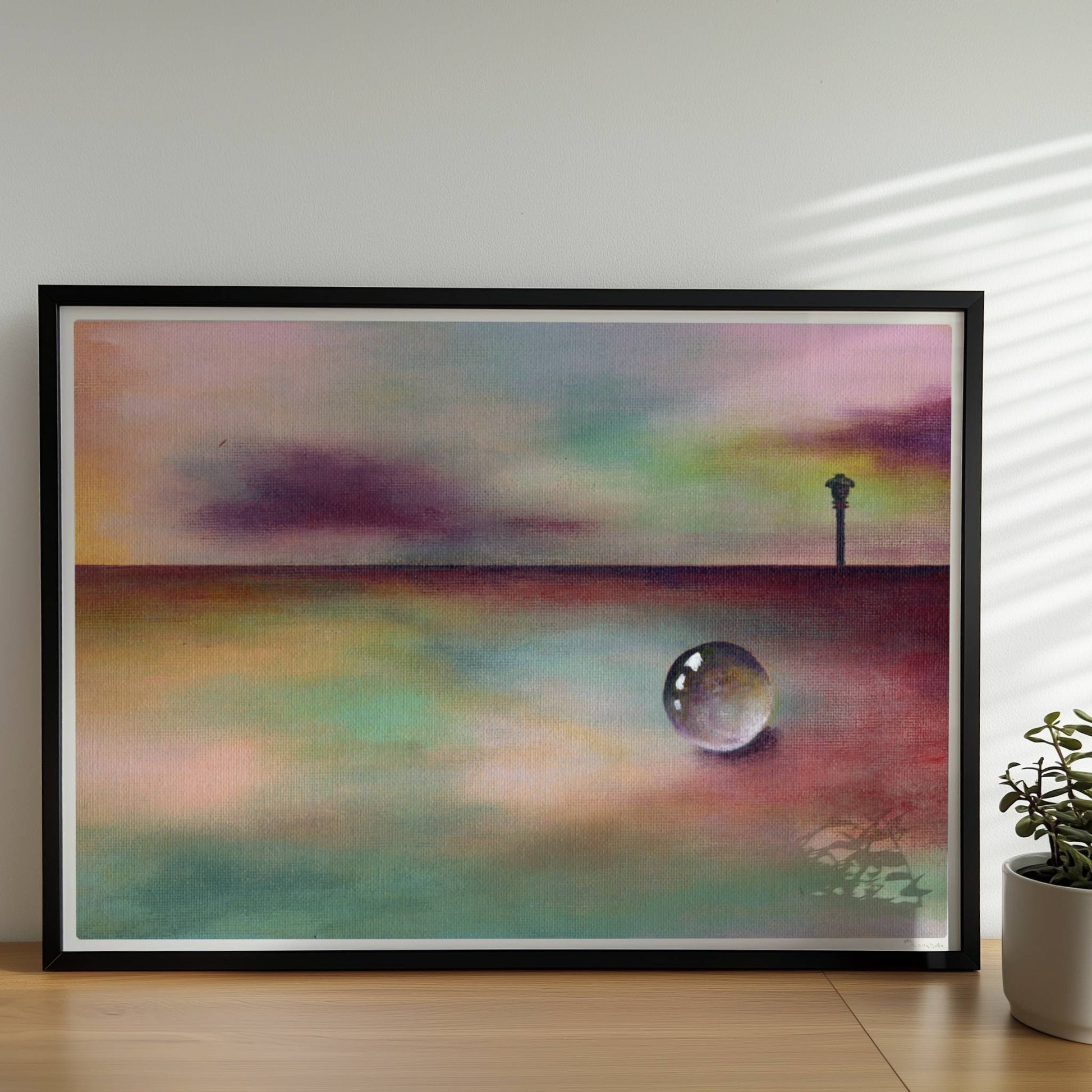Kugel auf regenbogenfarbener Landschaft mit entferntem Horizont.. Rahmen schwarz 70x50