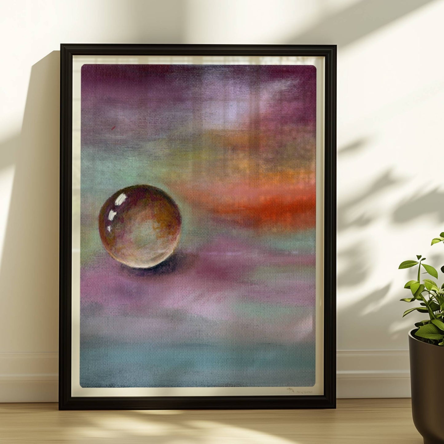 Schwebende Glaskugel vor farbenfrohem Himmel in Lila und Orange.. Rahmen schwarz 30x40