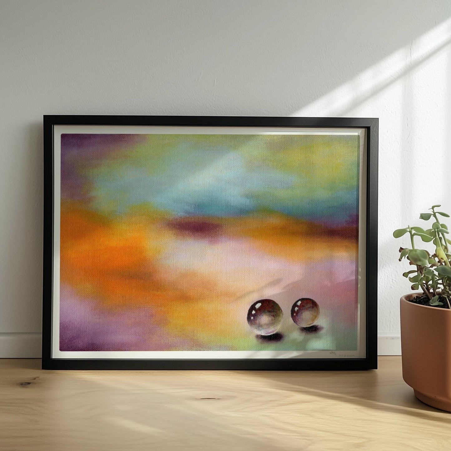 Zwei Glaskugeln auf farbigem Hintergrund mit weichen Verläufen.. Rahmen schwarz 40x30