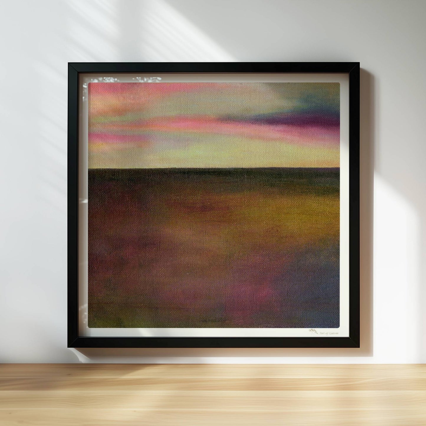 Einzelner goldener Tropfen vor farbigem Wolkenhimmel, surreal.. Rahmen schwarz 30x30