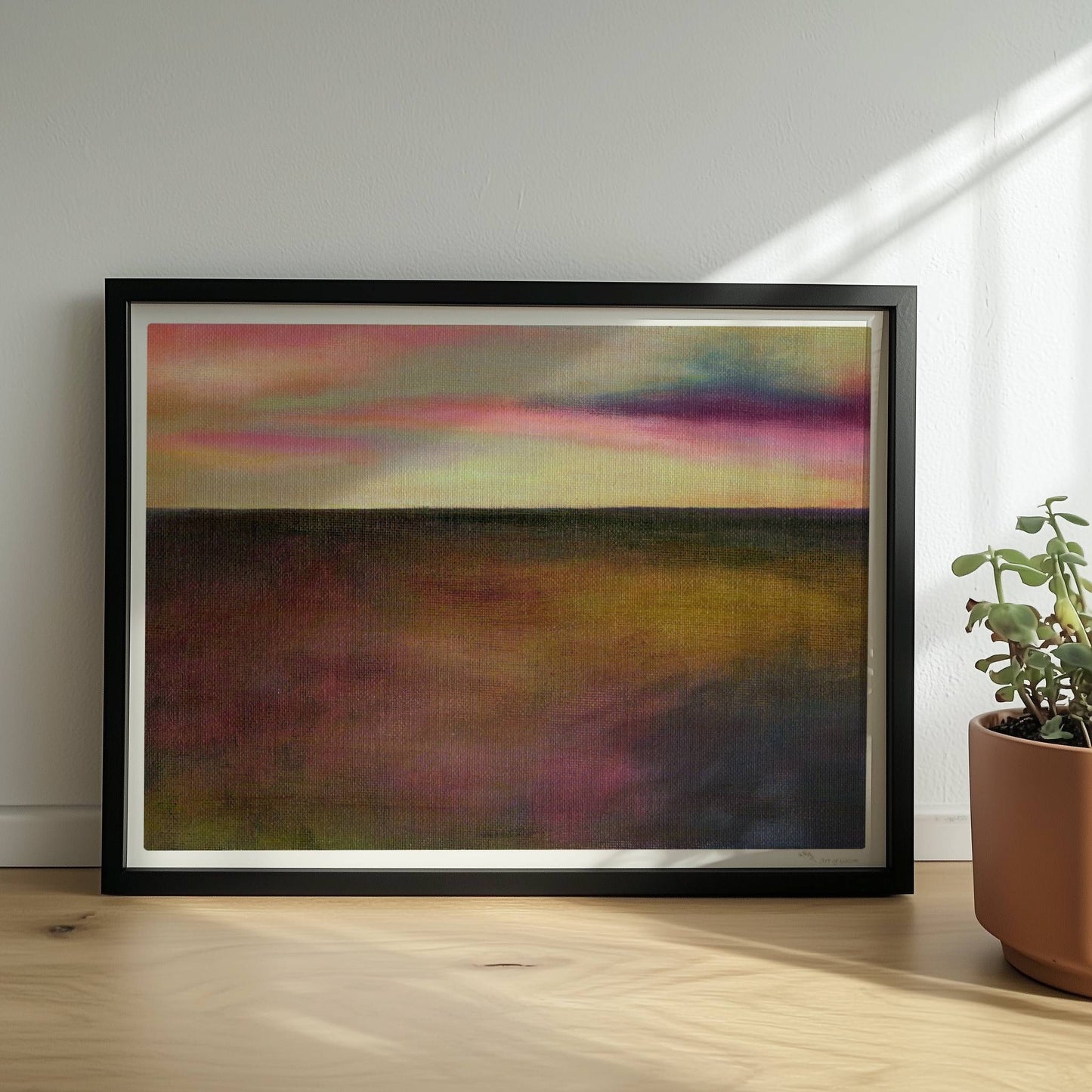 Einzelner goldener Tropfen vor farbigem Wolkenhimmel, surreal.. Rahmen schwarz 40x30