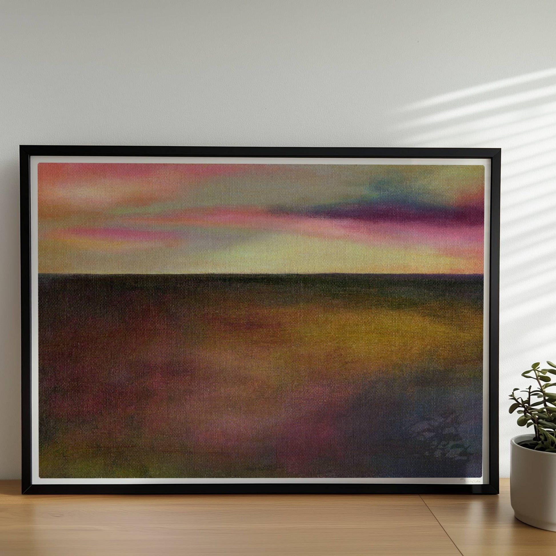 Einzelner goldener Tropfen vor farbigem Wolkenhimmel, surreal.. Rahmen schwarz 70x50