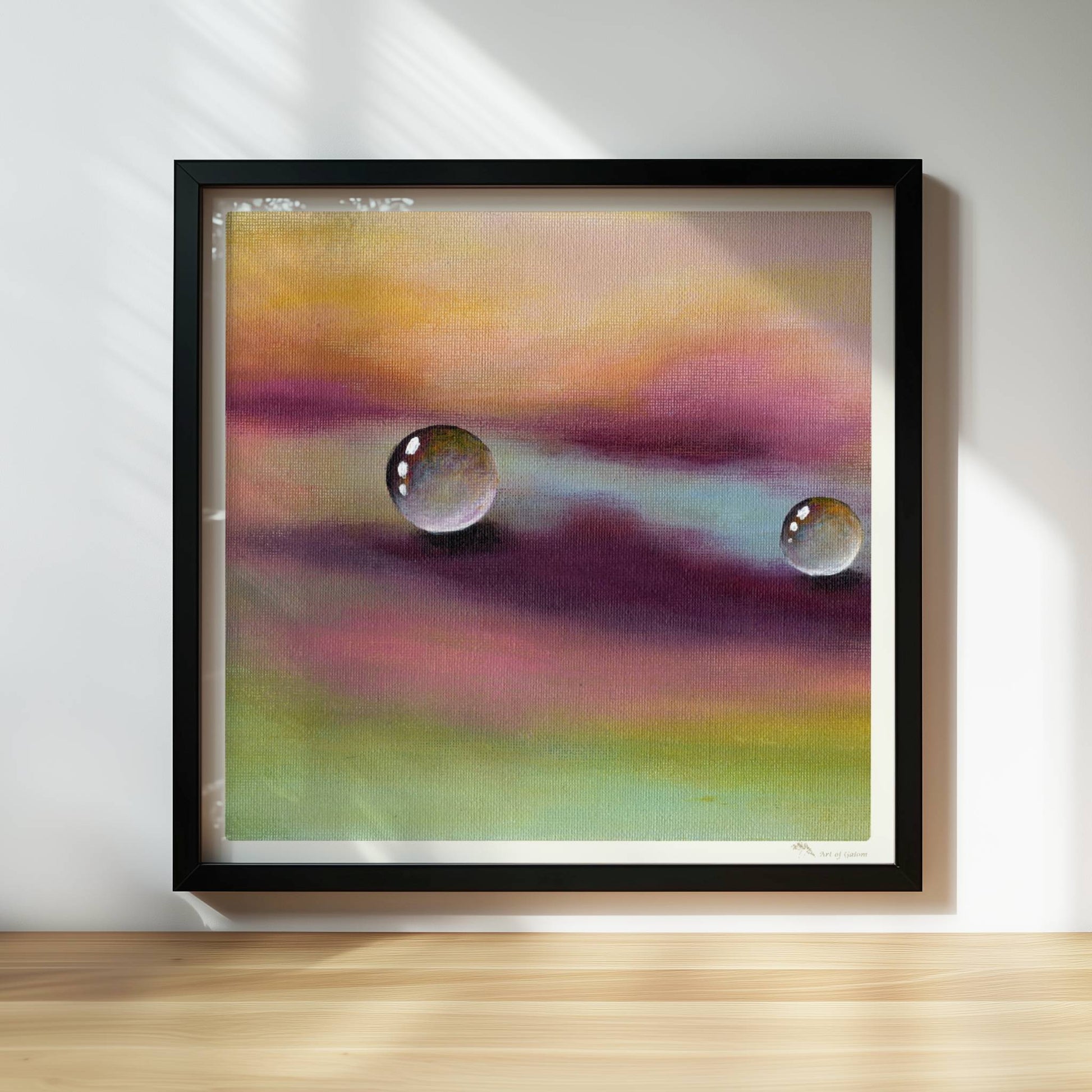 Zwei Glastropfen schweben über violettem und gelbem Himmel, surreal.. Rahmen schwarz 30x30