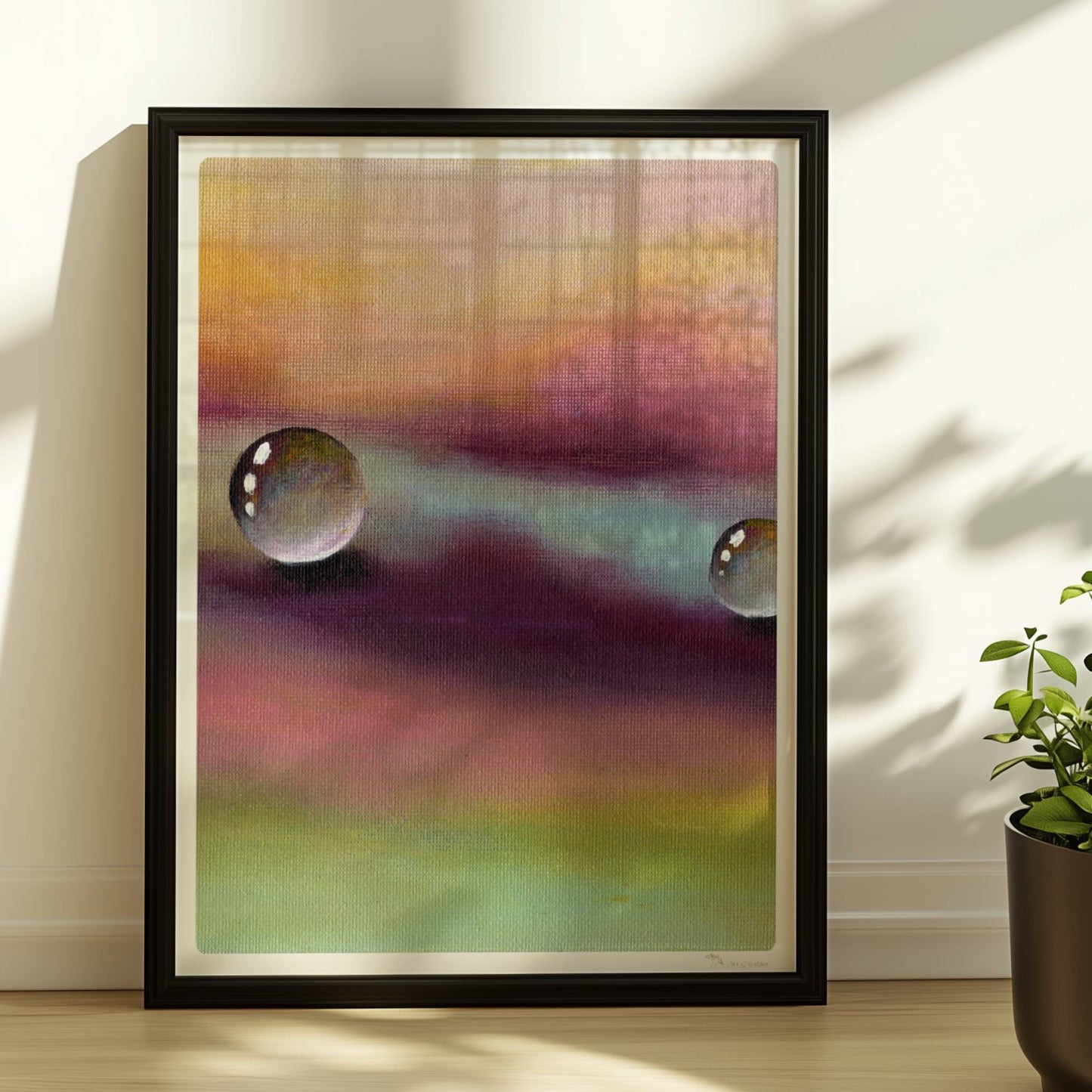 Zwei Glastropfen schweben über violettem und gelbem Himmel, surreal.. Rahmen schwarz 30x40