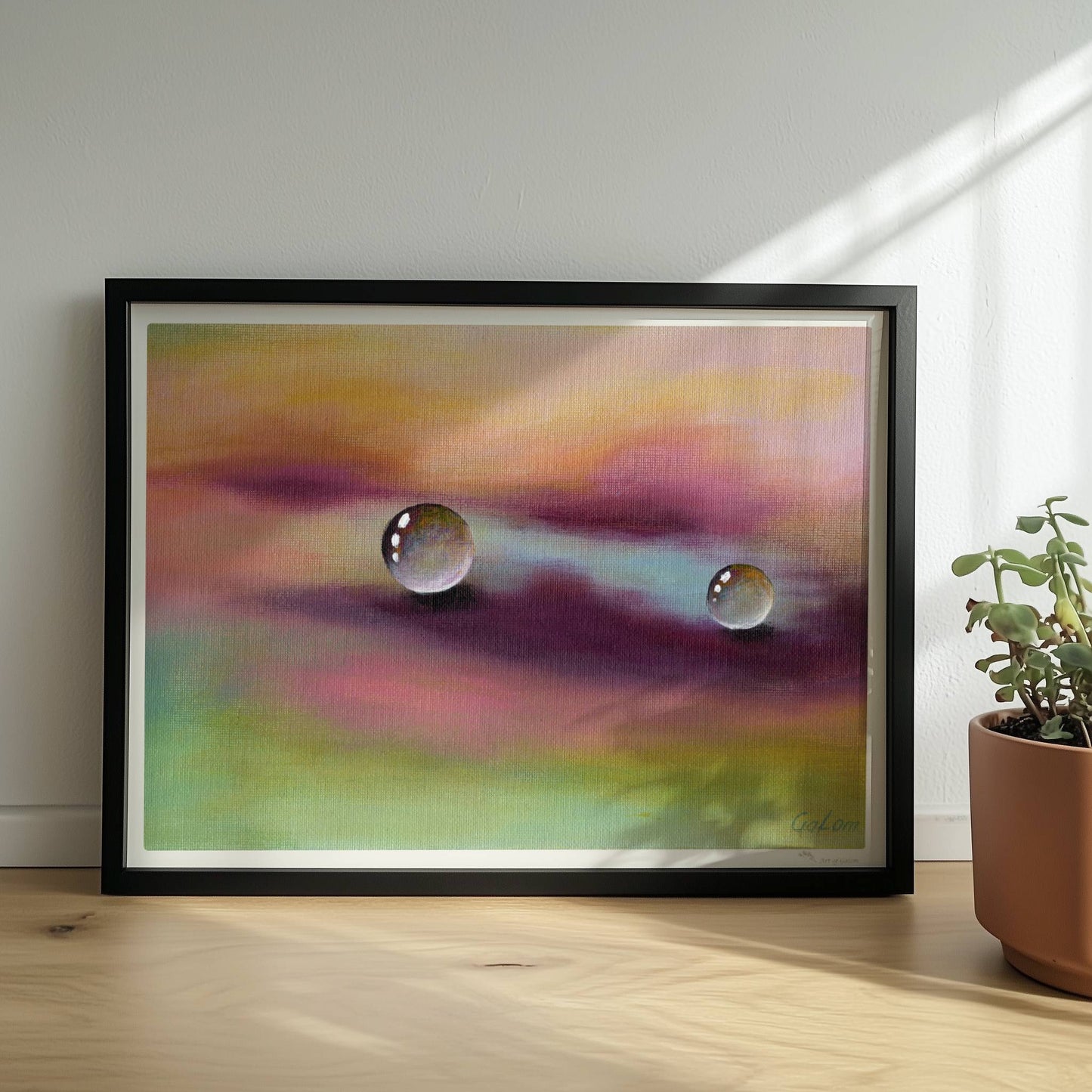 Zwei Glastropfen schweben über violettem und gelbem Himmel, surreal.. Rahmen schwarz 40x30