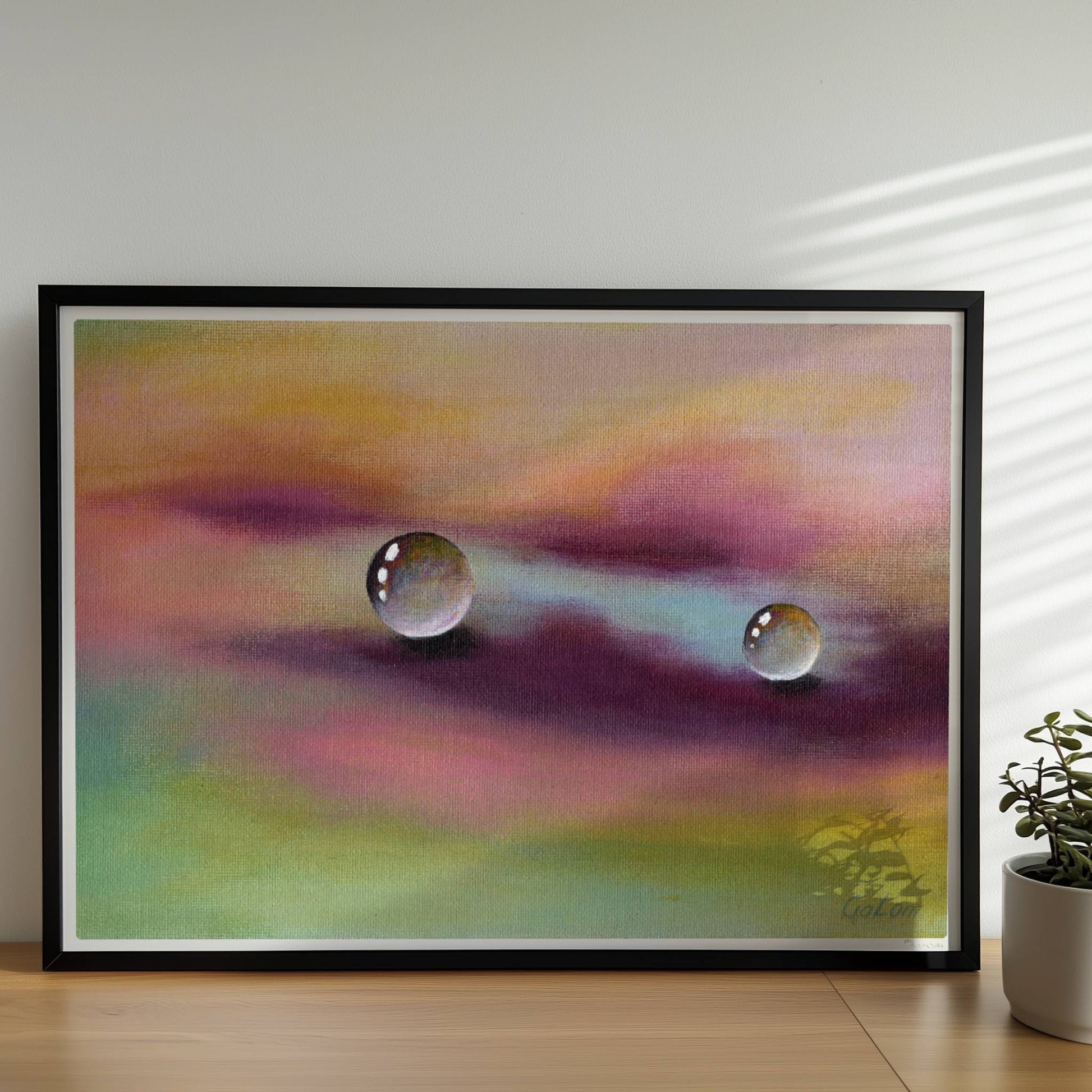 Zwei Glastropfen schweben über violettem und gelbem Himmel, surreal.. Rahmen schwarz 70x50