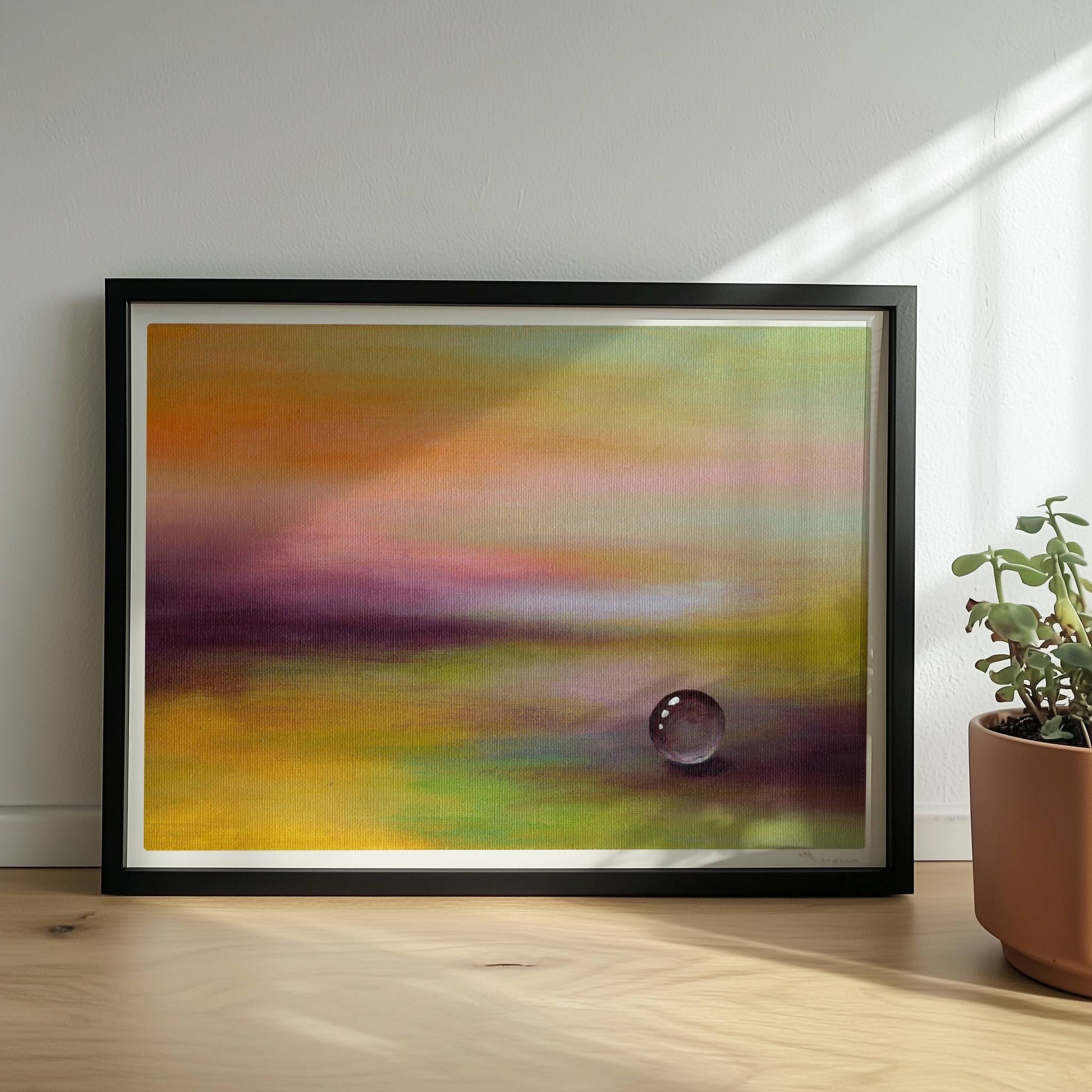 Einzelner Glastropfen in lila-gelber Traumlandschaft, beruhigend.. Rahmen schwarz 40x30