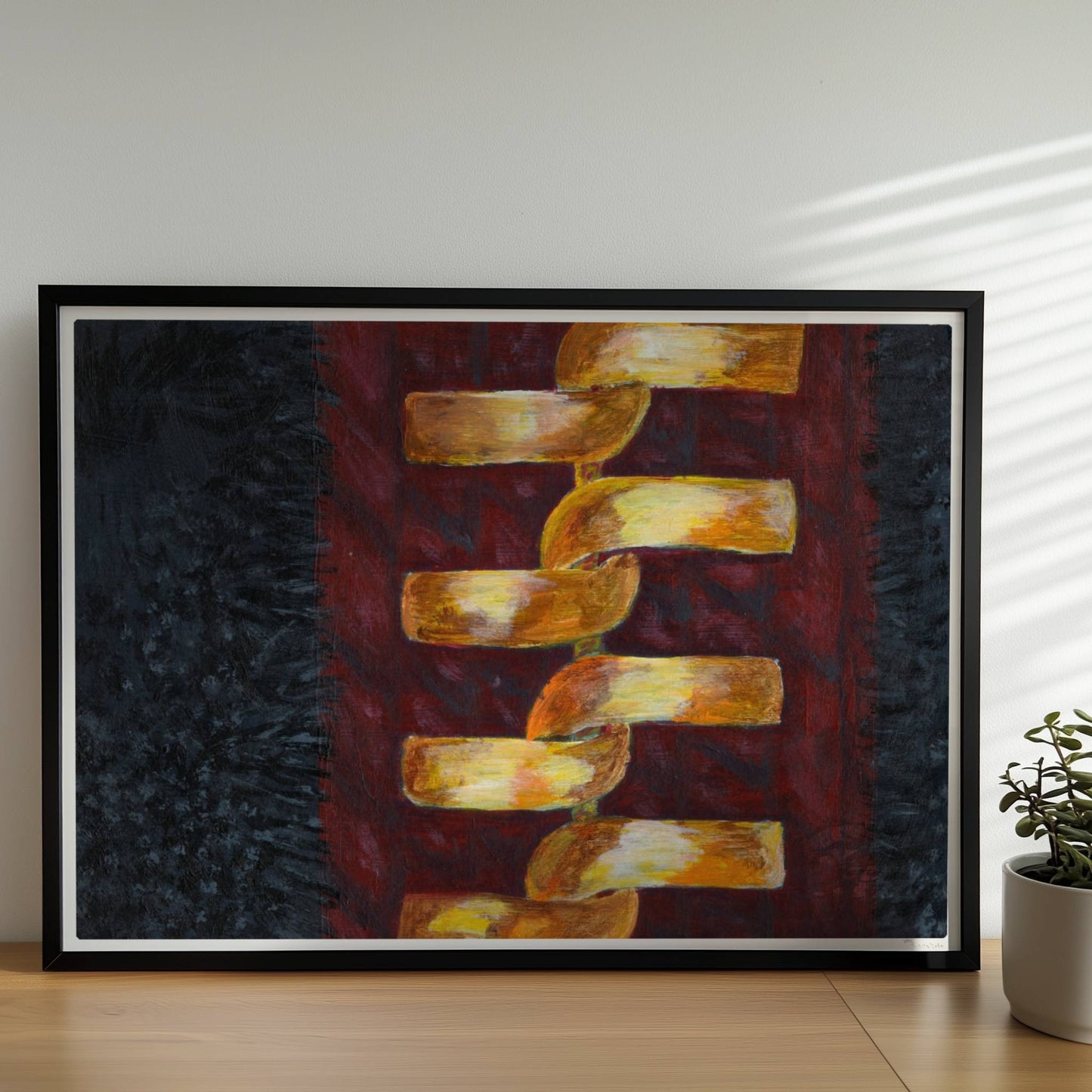 Goldene abstrakte Kette auf rotem Stoffhintergrund – modisch und modern.. Rahmen schwarz 70x50