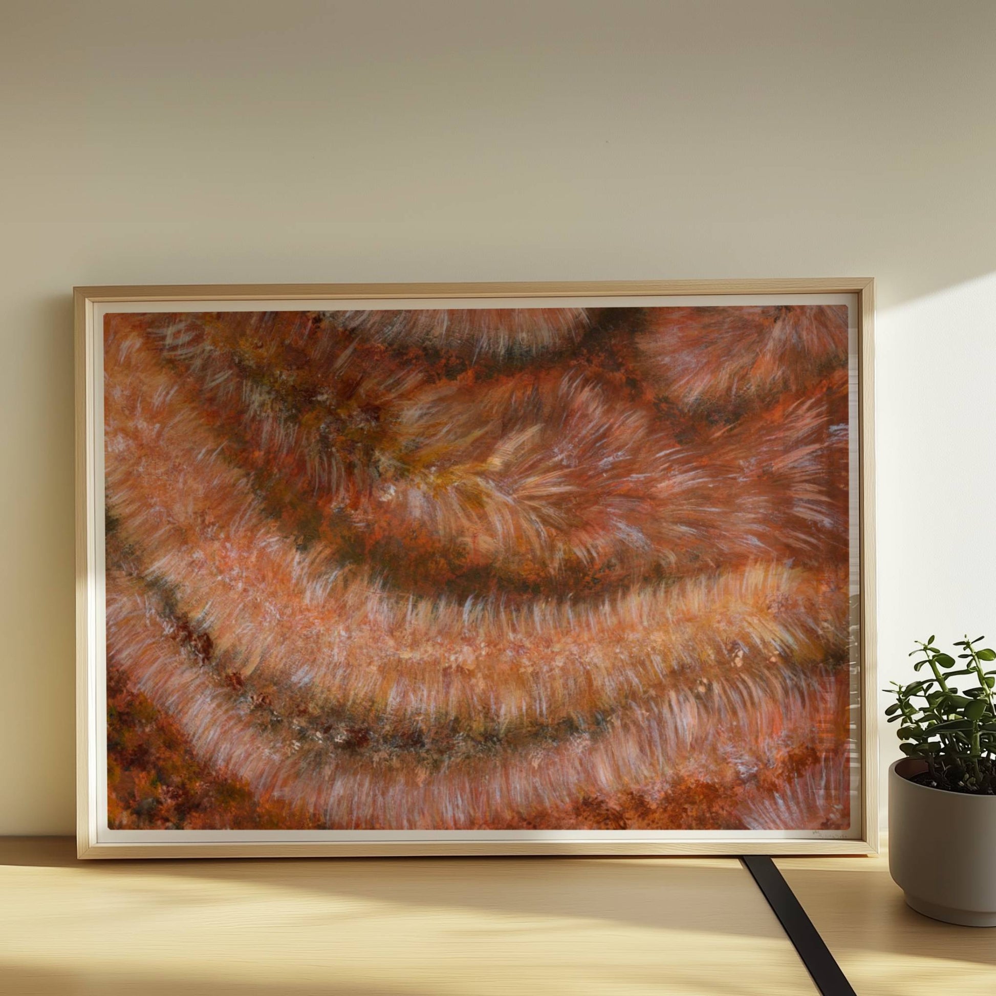 Nahaufnahme einer rotbraunen Kunstfellstruktur mit organischer Spiralform und samtigem Glanz.. Rahmen natur 70x50