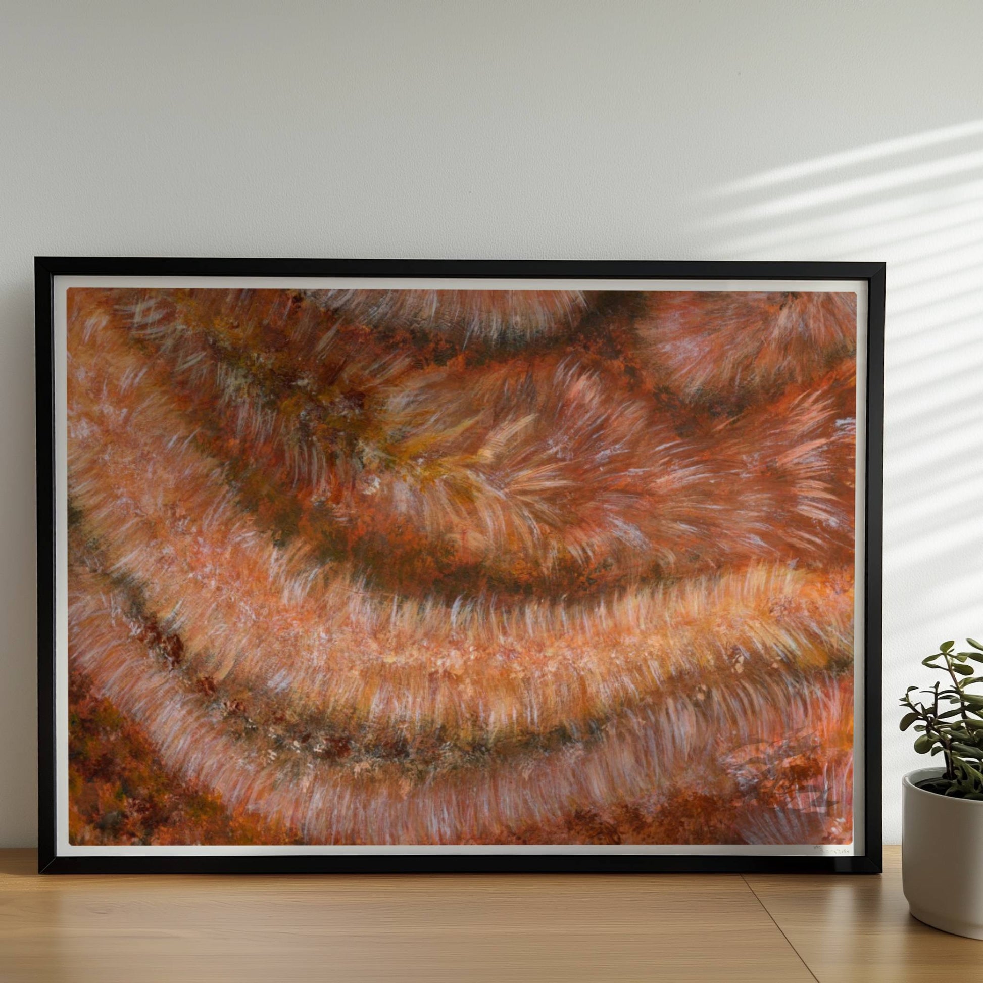 Nahaufnahme einer rotbraunen Kunstfellstruktur mit organischer Spiralform und samtigem Glanz.. Rahmen schwarz 70x50