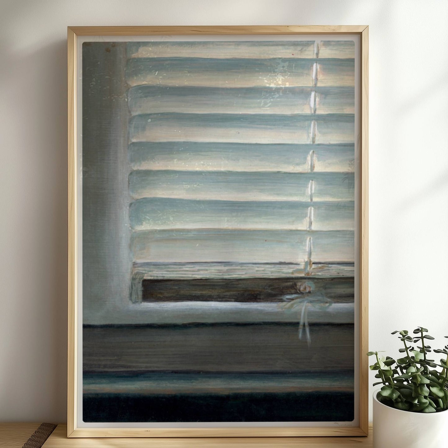 Detailaufnahme eines Fensters mit geschlossenen weißen Jalousien, subtiler Lichteinfall und sanfte Blautöne.. Rahmen natur 50x70