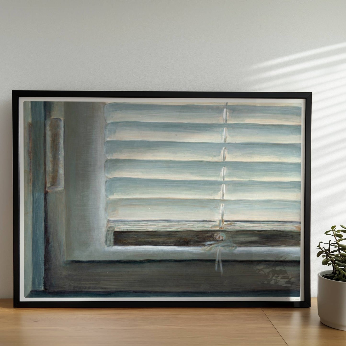 Detailaufnahme eines Fensters mit geschlossenen weißen Jalousien, subtiler Lichteinfall und sanfte Blautöne.. Rahmen schwarz 70x50