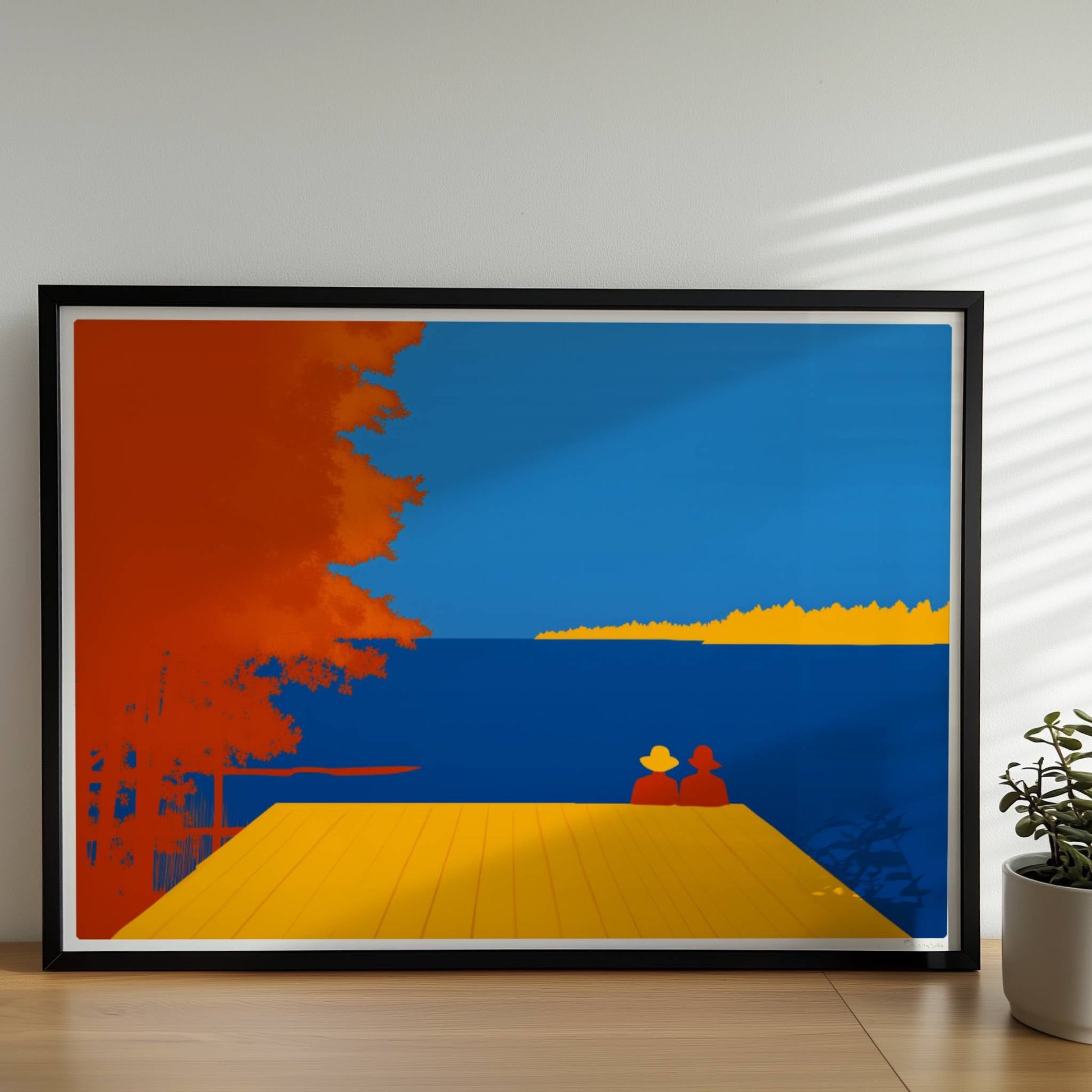 Zwei Personen auf einem Steg mit Blick auf einen leuchtend blauen See, flankiert von herbstlichen orangefarbenen Bäumen.. Rahmen schwarz 70x50