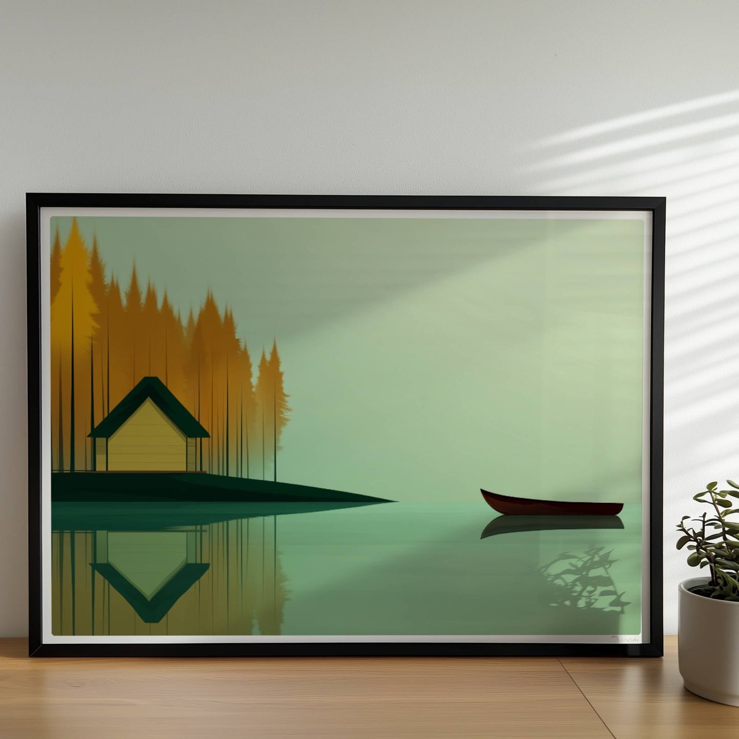 Gelbes Häuschen am See mit grünem Dach, umgeben von herbstlichen Bäumen und einem ruhigen Kanu auf spiegelndem Wasser.. Rahmen schwarz 70x50